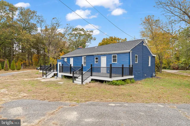 a view of a house with a patio and a yard
