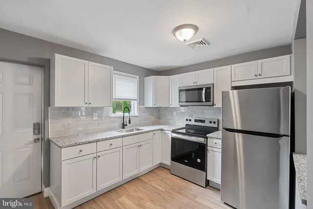 a kitchen with a sink stainless steel appliances and cabinets