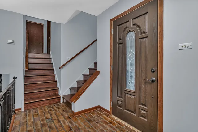 a view of a hallway with entryway and wooden floor