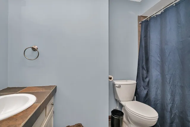 a white toilet sitting next to a bathroom sink and tub
