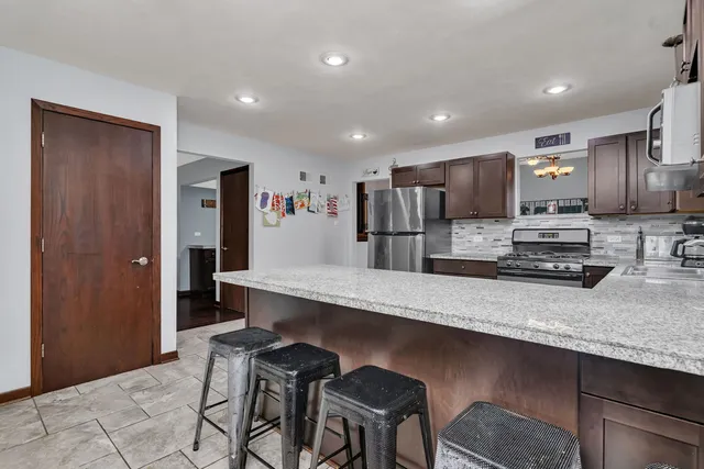 a large kitchen with granite countertop lots of counter space and stainless steel appliances