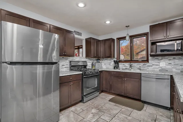 a kitchen with granite countertop stainless steel appliances and wooden cabinets