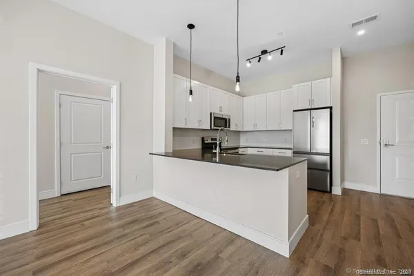 a kitchen with granite countertop a refrigerator stove and sink