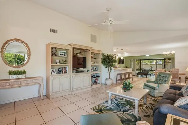 a living room with furniture a flat screen tv and kitchen view