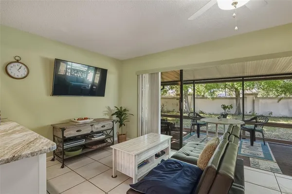 a living room with furniture a flat screen tv and a floor to ceiling window