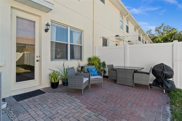 a view of a patio with couple of chairs and a potted plant