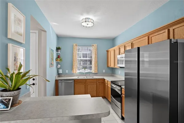 a kitchen with stainless steel appliances a sink a counter top space cabinets and a window
