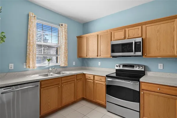 a kitchen with stainless steel appliances granite countertop white cabinets sink and microwave