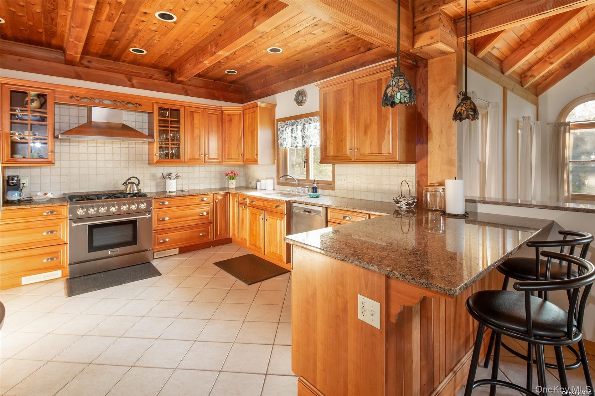 48 Oakhurst Road Hampton Bays, NY 11946 - Photo 11 of 25 a kitchen with stainless steel appliances granite countertop a sink and a counter space