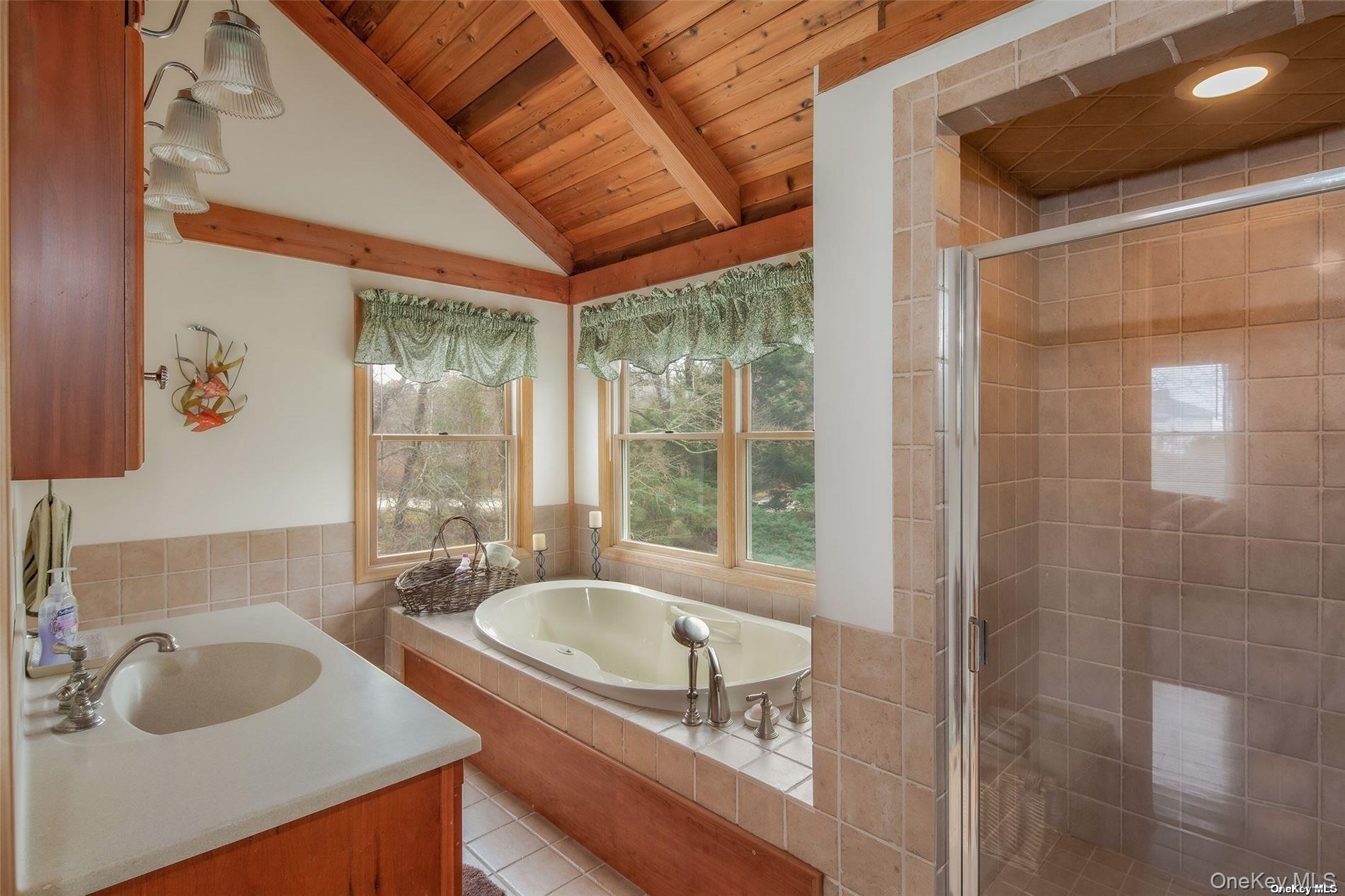48 Oakhurst Road Hampton Bays, NY 11946 - Photo 18 of 25 a bathroom with a tub sink and mirror