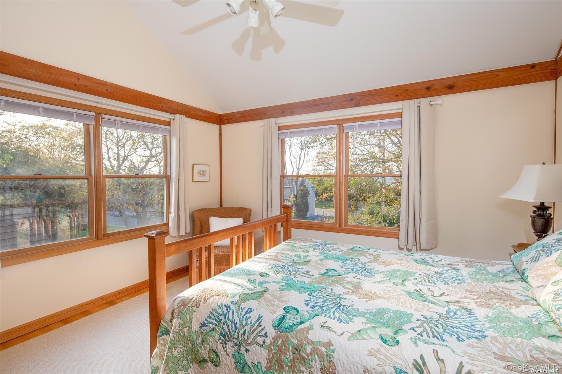 48 Oakhurst Road Hampton Bays, NY 11946 - Photo 19 of 25 a bedroom with a large bed and a large window with balcony view