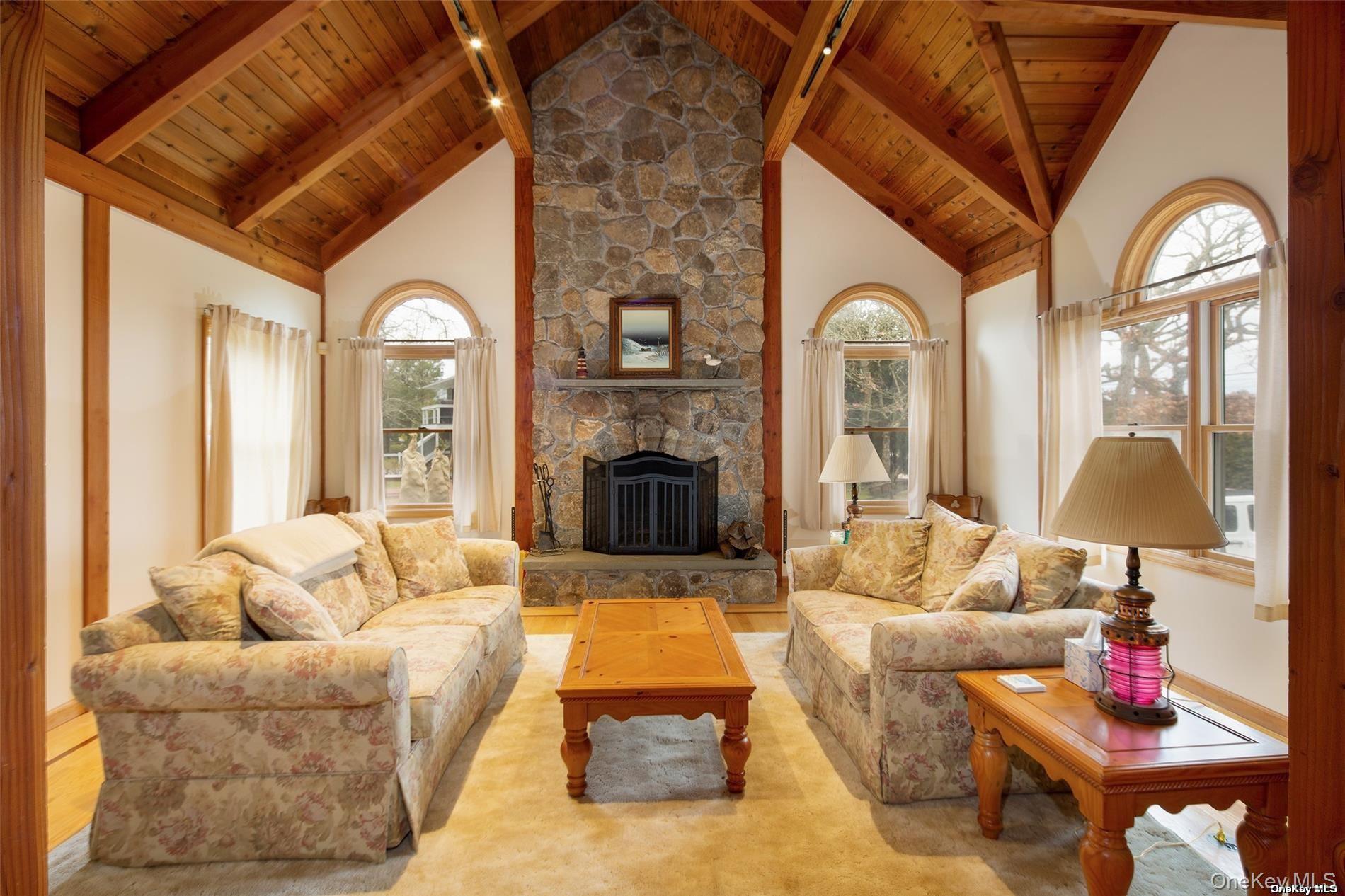 48 Oakhurst Road Hampton Bays, NY 11946 - Photo 9 of 25 a living room with furniture and a fireplace