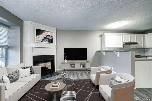 a living room with furniture a fireplace and a flat screen tv