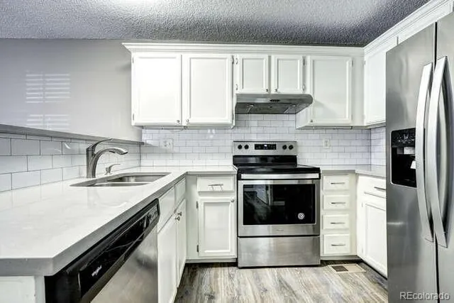 a kitchen with stainless steel appliances kitchen island granite countertop a refrigerator and a stove top oven
