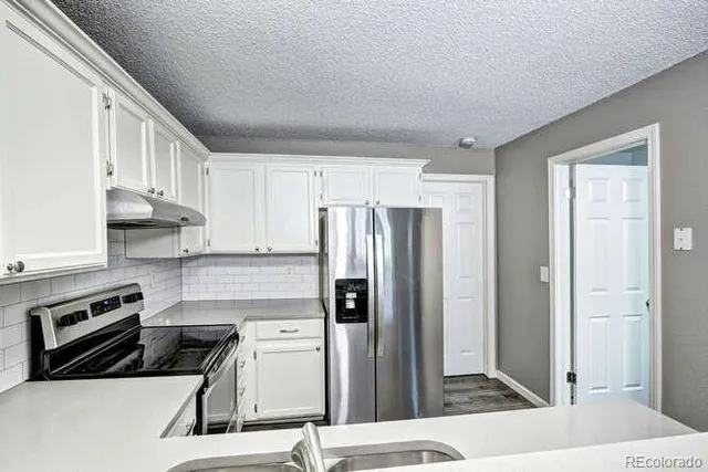 a kitchen with stainless steel appliances granite countertop a sink stove and cabinets