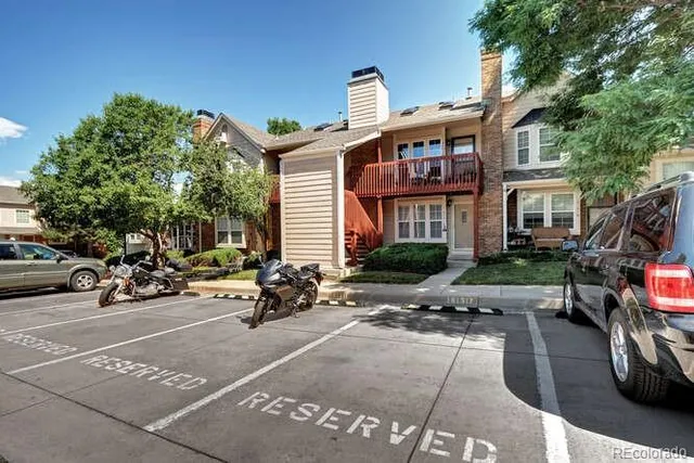 a view of a brick house with many windows and a table and chairs