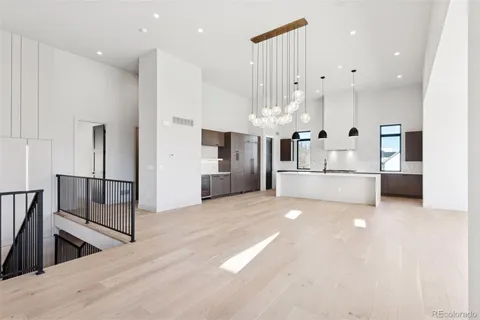 a large white kitchen with granite countertop a large counter top and stainless steel appliances