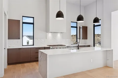 a kitchen with stainless steel appliances kitchen island granite countertop a sink a stove and refrigerator