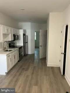 a view of kitchen with wooden floor and electronic appliances