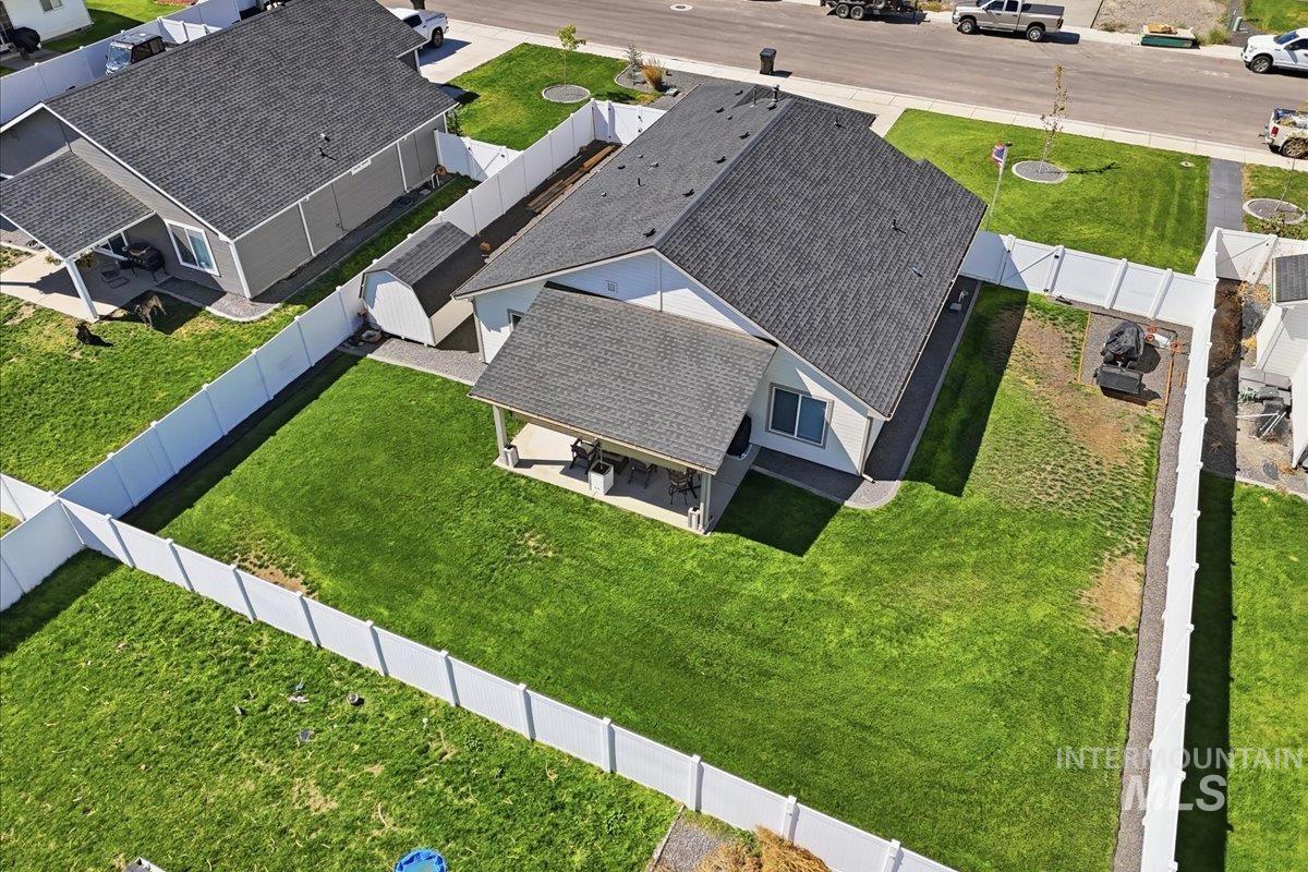 918 Sierra Street Vale, OR 97918 - Photo 37 of 42 Well-maintained exterior with a covered patio, white privacy fencing, and a separate storage shed