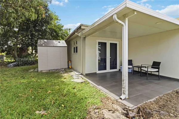 a backyard of a house with table and chairs