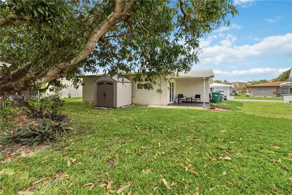 a white house that has a tree in front of it