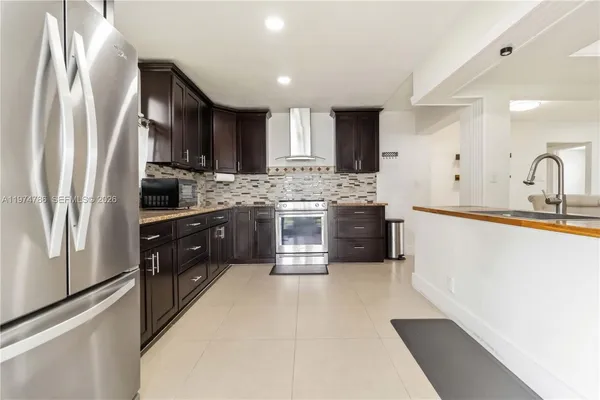 a kitchen with stainless steel appliances granite countertop a refrigerator and a sink