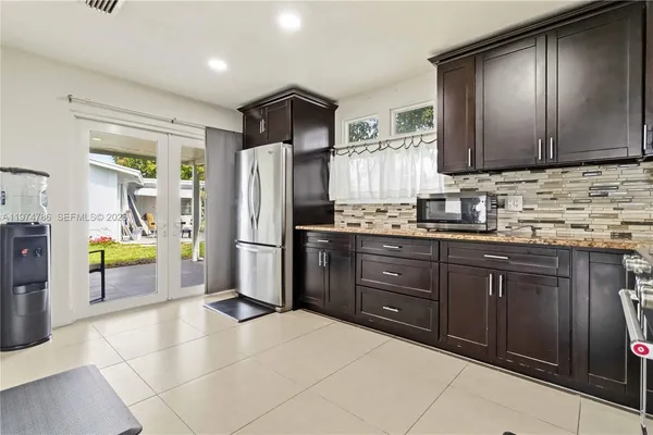 a kitchen with stainless steel appliances granite countertop a refrigerator and a sink