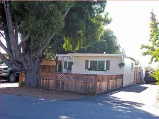 a view of a house with a yard and wooden fence