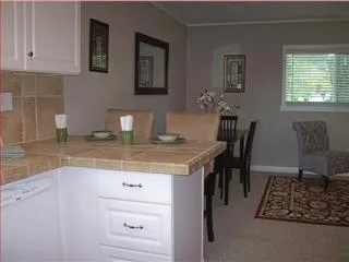 a kitchen with granite countertop a table chairs stove and cabinets