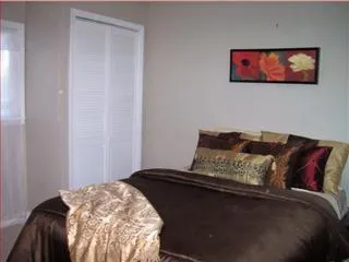 a bedroom with a bed and a painting on the wall