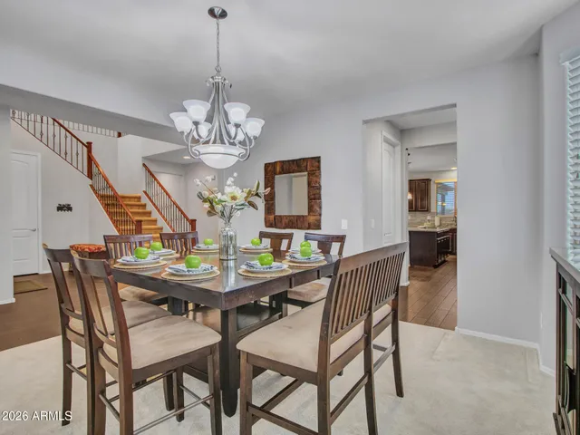 a kitchen with kitchen island granite countertop wooden cabinets a stove a microwave a island with a dining table and chairs