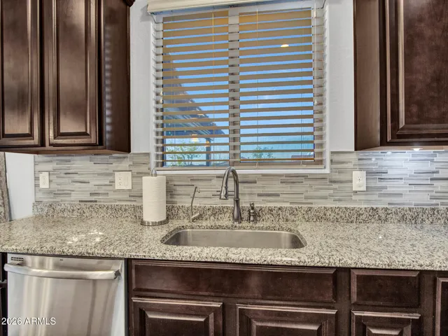 a view of a backyard with couches under an umbrella