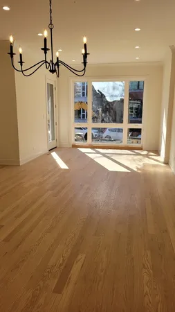 a view of an empty room with closet and a window
