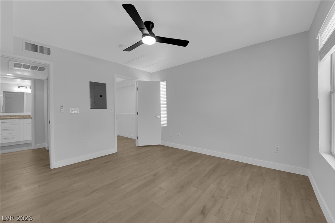 8101 West Flamingo Road, Unit 2152 Las Vegas, NV 89147 - Photo 16 of 45 Well-lit living area with rich wood flooring and a modern ceiling fan for comfort.