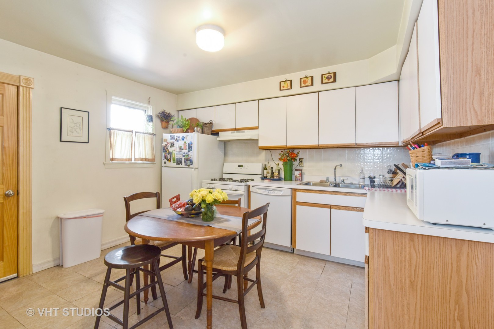 1424 West Fletcher Street Chicago, IL 60657 - Photo 15 of 24 a kitchen with a table chairs and a refrigerator