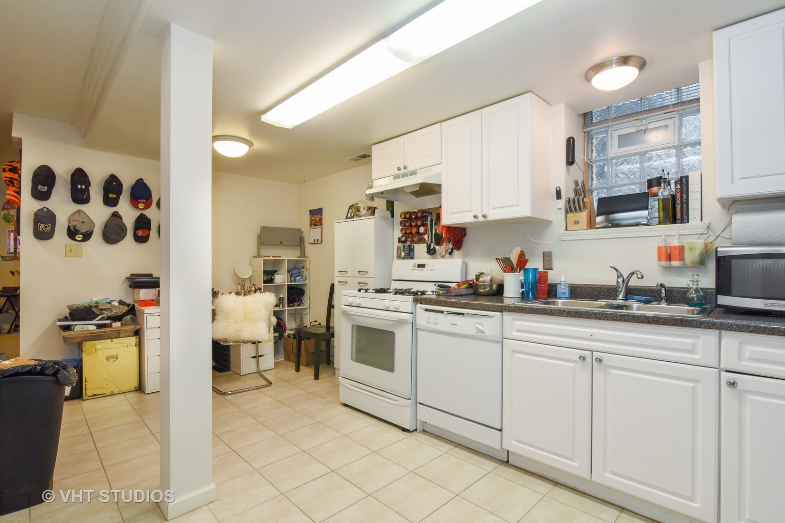 1424 West Fletcher Street Chicago, IL 60657 - Photo 22 of 24 a kitchen with white cabinets and sink