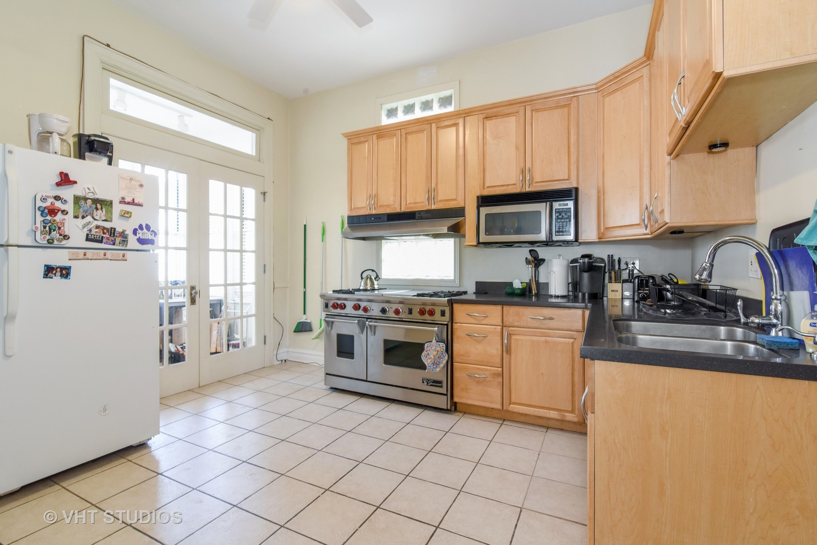 1424 West Fletcher Street Chicago, IL 60657 - Photo 5 of 24 a kitchen with a stove a sink and a refrigerator