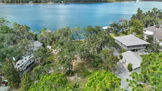 an aerial view of a house with a yard and lake view
