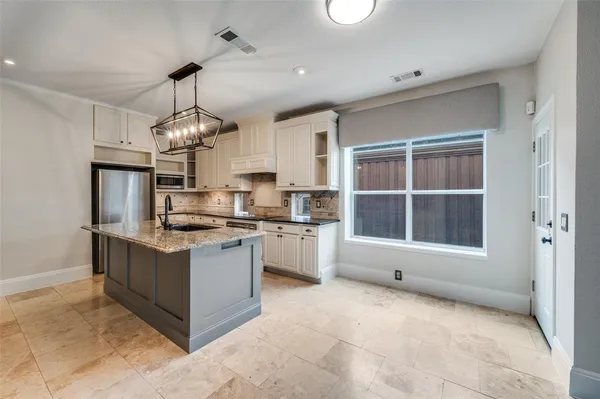 a kitchen with stainless steel appliances granite countertop a stove and a refrigerator