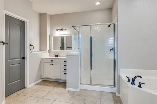a bathroom with a bathtub sink and mirror