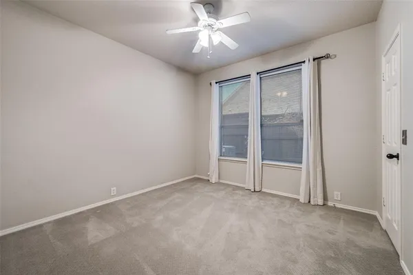 an empty room with closet and a ceiling fan