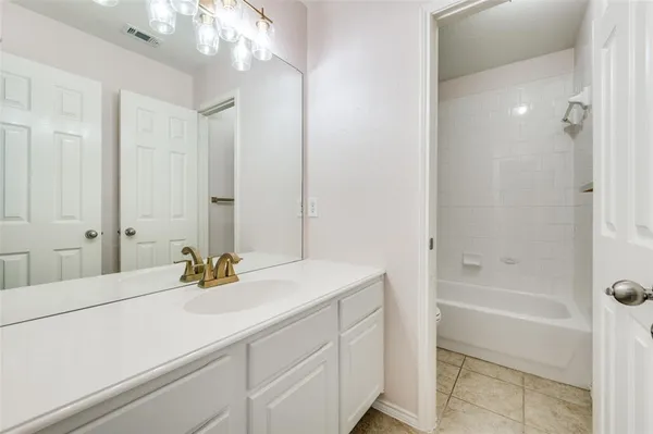 a bathroom with a tub sink and mirror