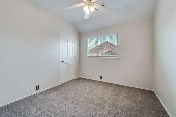 an empty room with closet and windows