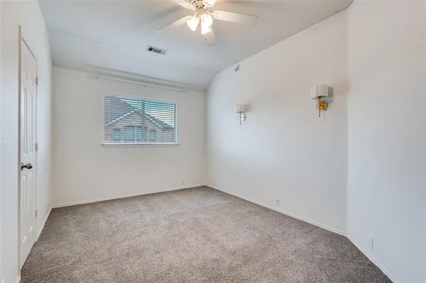 an empty room with a window and a chandelier fan