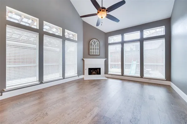 a view of an empty room with a window and fireplace