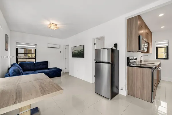 a living room with a couch and a refrigerator