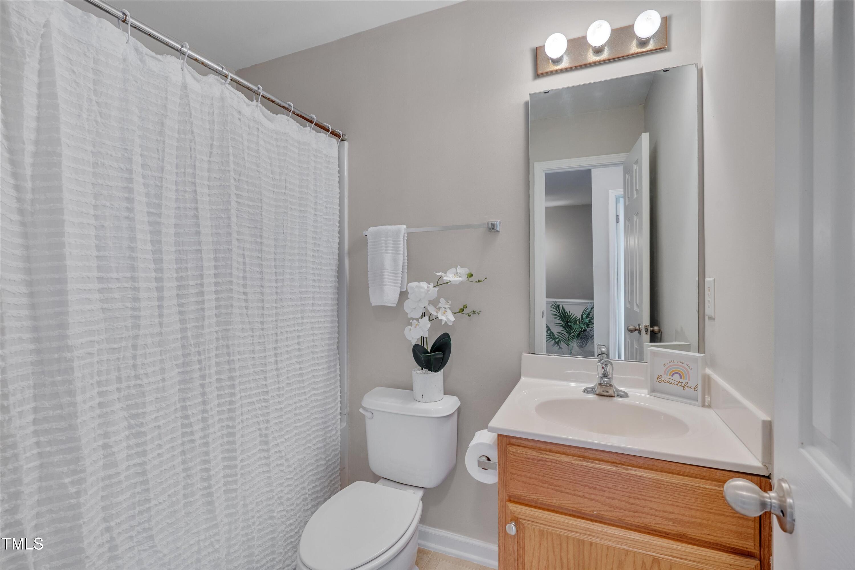 7704 Averette Field Drive Raleigh, NC 27616 - Photo 20 of 25 a bathroom with a sink a toilet and mirror