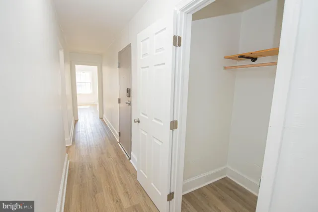 a view of a hallway with wooden floor and staircase