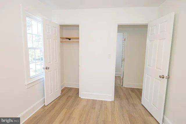 an empty room with wooden floor and a window